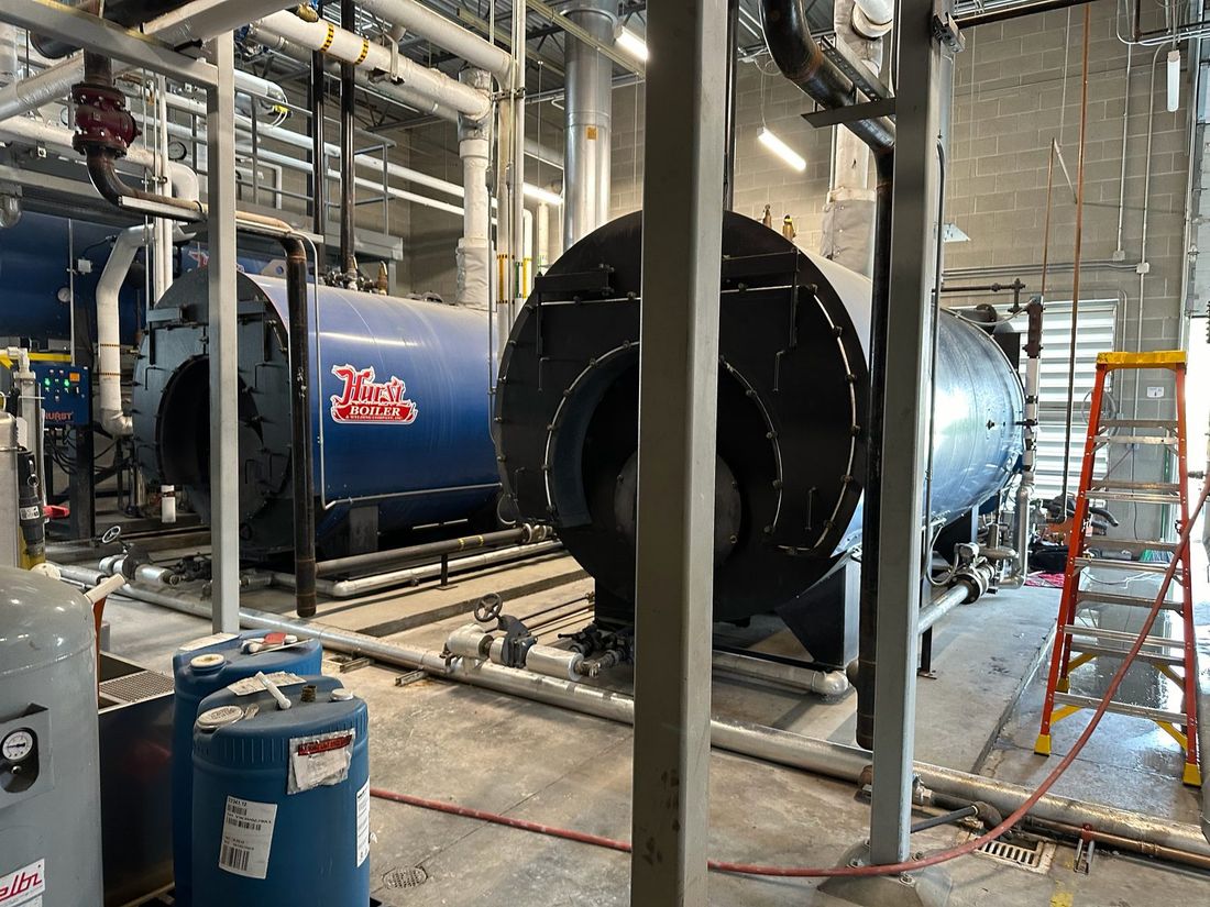 Boilers and piping in a commercial boiler room installed by Grant Mechanical